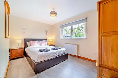 a bedroom with a bed and a window at La Fortuna Lodges in Stirling