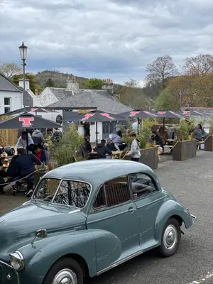 an old blue car parked in a parking lot at The Inverkip Restaurant, Bar & Hotel in Inverkip