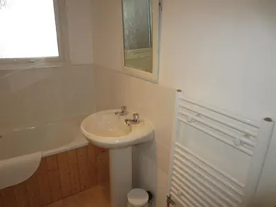 a white bathroom with a sink and a bath tub at Oystershell Lodge in Otter Ferry