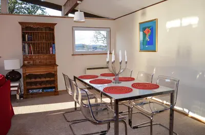 a dining room with a table and chairs at Oystershell Lodge in Otter Ferry