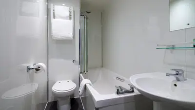 a white bathroom with a toilet and a sink at Best Western Glasgow Hotel in Glasgow