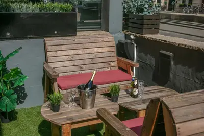 a wooden chair with a bottle of wine on a table at Best Western Glasgow Hotel in Glasgow
