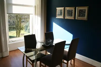 a dining room with a glass table and chairs at Dreamhouse Apartments Glasgow West End in Glasgow