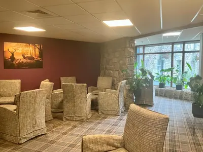a waiting room with wicker chairs and a stone wall at Britannia Edinburgh Hotel in Edinburgh
