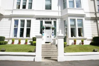 a white building with a white door and stairs at Ambassador Hotel in Glasgow