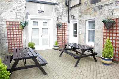 two picnic tables sitting in front of a building at Ambassador Hotel in Glasgow