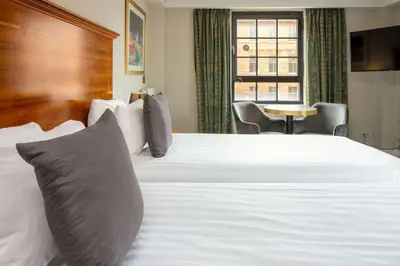 a hotel room with a large white bed with pillows at Glasgow Argyle Hotel, BW Signature Collection in Glasgow
