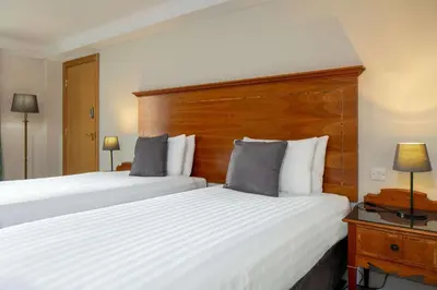a hotel room with two beds and a headboard at Glasgow Argyle Hotel, BW Signature Collection in Glasgow