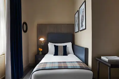 a hotel room with a bed with a plaid blanket at Kimpton Charlotte Square by IHG in Edinburgh