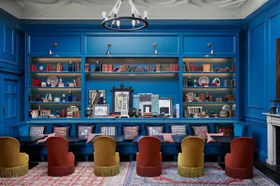 a blue library with chairs and bookshelves at Kimpton Charlotte Square by IHG in Edinburgh