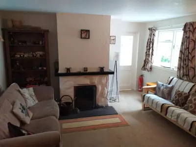 a living room with a fireplace and a couch at Craignavie Cottage in Killin