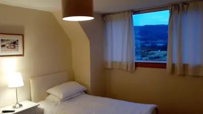 a bedroom with a bed and a window at Feochan View in Oban