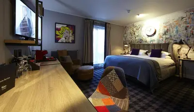 a hotel room with a bed and a tv at Malmaison Glasgow in Glasgow