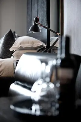 a lamp on a table next to a couch with a plate at Malmaison Glasgow in Glasgow