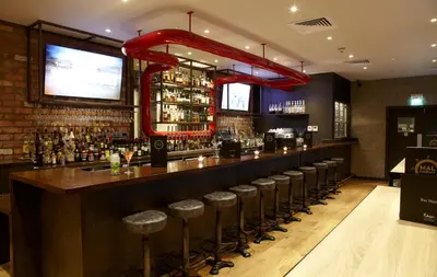 a bar with a row of stools in a room at Malmaison Glasgow in Glasgow