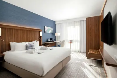 a hotel room with a large bed and a tv at Courtyard by Marriott Glasgow Airport in Paisley