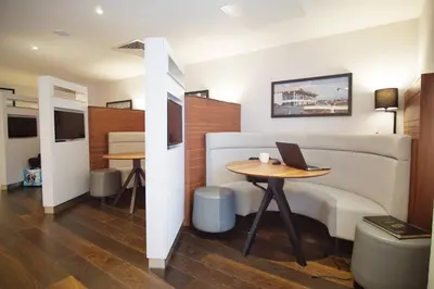 a room with a bed and a table with a laptop on it at Courtyard by Marriott Glasgow Airport in Paisley