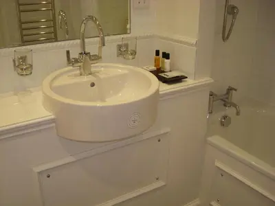 a white bathroom with a sink and a tub at Annandale Arms Hotel in Moffat