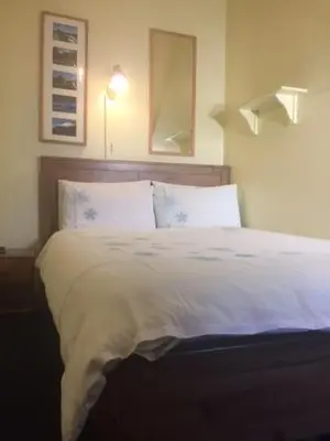 a bed with white sheets and pillows in a bedroom at Badjao B&B in Edinburgh