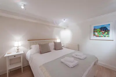 a bedroom with a white bed with two towels on it at Apartment Jamaica Street 7 in Edinburgh