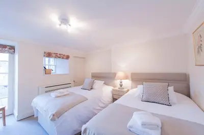two beds in a room with white walls at Apartment Jamaica Street 7 in Edinburgh