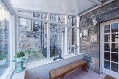 a window with a bench in a room with a stone wall at Apartment Jamaica Street 7 in Edinburgh