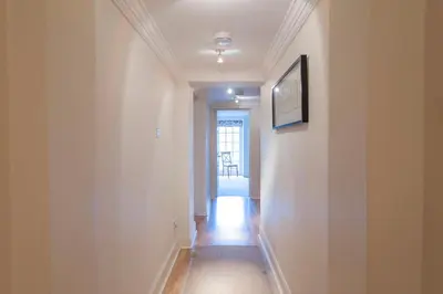 a hallway with white walls and a television on a wall at Apartment Jamaica Street 7 in Edinburgh