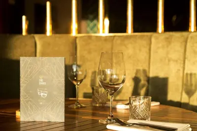two wine glasses sitting on a wooden table at DoubleTree by Hilton Edinburgh - Queensferry Crossing in North Queensferry