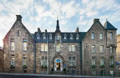 an old brick building with a cross on top at Leonardo Edinburgh City in Edinburgh