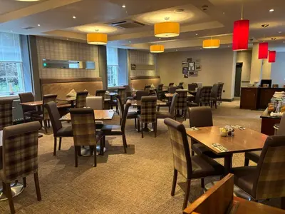 a restaurant with tables and chairs in a room at Leonardo Edinburgh City in Edinburgh