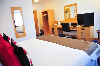 a hotel room with a bed and a desk with a computer at The Park Hotel in Kilmarnock