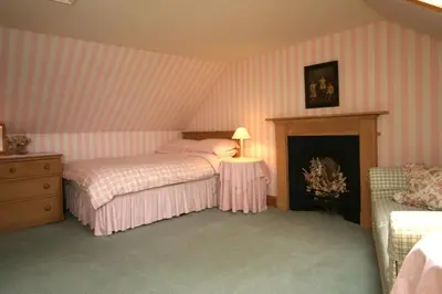 a bedroom with two beds and a fireplace at Springburn Cottage in Strachur