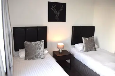 two beds sitting next to each other in a room at Kelpies Serviced Apartments - McClean in Falkirk