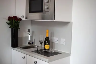 a kitchen with a bottle of wine and a sink at Kelpies Serviced Apartments in Falkirk