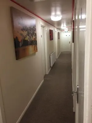 a hallway of an office with a painting on the wall at Laughing Buddha Guesthouse in Uddingston