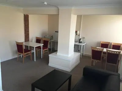 a room with a table and chairs and a dining room at Laughing Buddha Guesthouse in Uddingston
