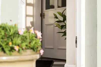 a white door with flowers in a porch at Glenegedale House in Kintra