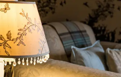 a lamp sitting on top of a couch with a pillow at Glenegedale House in Kintra