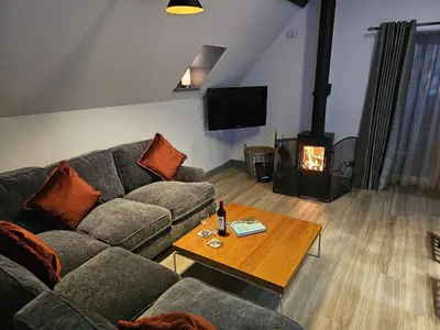 a living room with a couch and a wood stove at Melfort Pier & Harbour Resort in Kilmelford