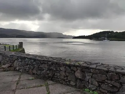 a stone wall next to a body of water at Melfort Pier & Harbour Resort in Kilmelford