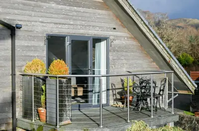a screened porch with a table and chairs on a house at Melfort Pier & Harbour Resort in Kilmelford
