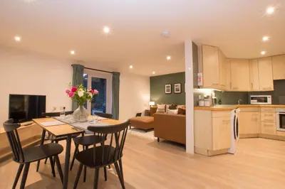 a kitchen and living room with a table and chairs at Melfort Pier & Harbour Resort in Kilmelford