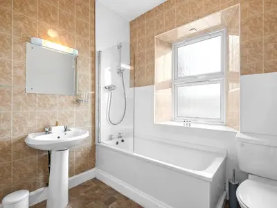 a bathroom with a sink and a tub and a toilet at No. 1 Charlotte Street in Port Ellen