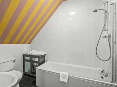 a bathroom with a shower and a tub and a toilet at No. 1 Charlotte Street in Port Ellen