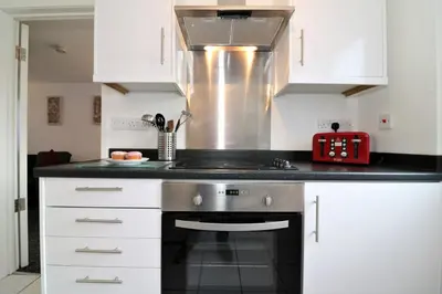 a kitchen with white cabinets and a stove top oven at Signature - Atholl House Glasgow Airport in Paisley