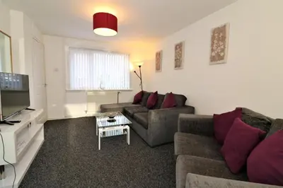 a living room with a couch and a tv at Signature - Atholl House Glasgow Airport in Paisley