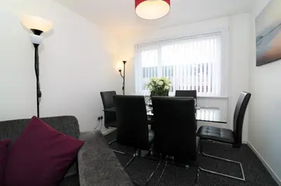 a living room with a table and chairs and a couch at Signature - Atholl House Glasgow Airport in Paisley