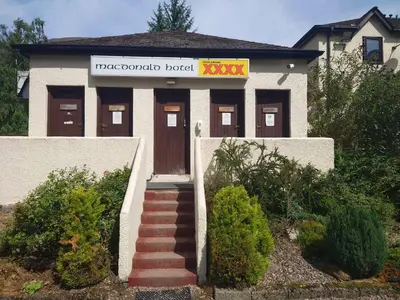 a building with a sign that reads tropologota hotel at MacDonald Cabins in Kinlochleven