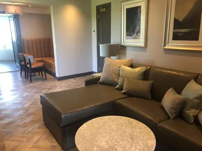 a living room with a brown couch and a table at Riverside Lodge Hotel in Irvine