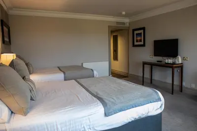 a hotel room with two beds and a television at Riverside Lodge Hotel in Irvine